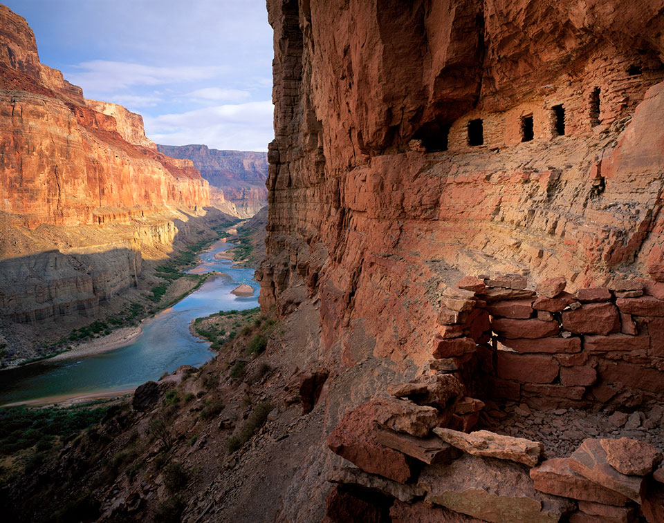 Ancestral Puebloan granaries cling to the wall of Marble Canyon as the Colorado River flows below. | Jack Dykinga