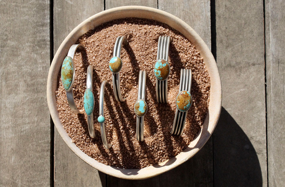 Bracelet samples in a pot of sand