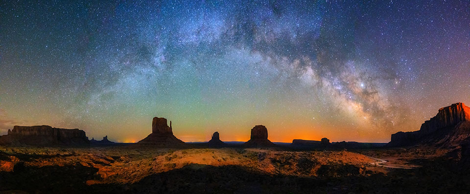 The Mittens and Merrick Butte reach for the stars at Monument Valley Navajo Tribal Park, which straddles Arizona’s state line with Utah. According to Navajo mythology, the mischievous Coyote created the Milky Way by impatiently tossing stars into the sky. | Sean Parker
