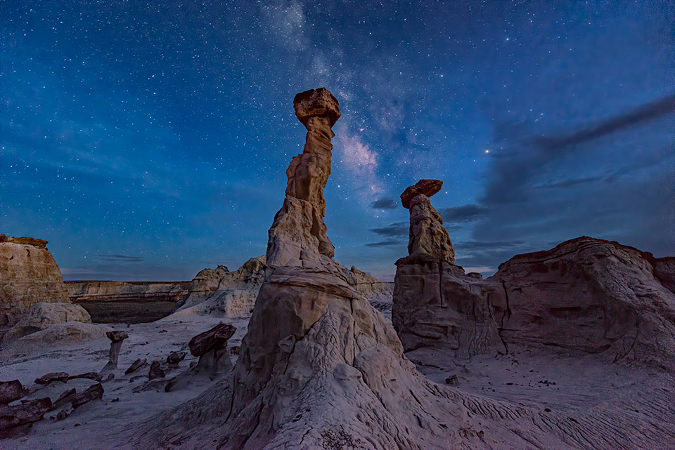 Hoodoos punctuate a serene nighttime view in Blue Canyon, on Hopi Tribe land in Northeastern Arizona. Visiting this isolated canyon, which is known for otherworldly formations and colorful rock layers, requires a Hopi guide. By Doug Koepsel