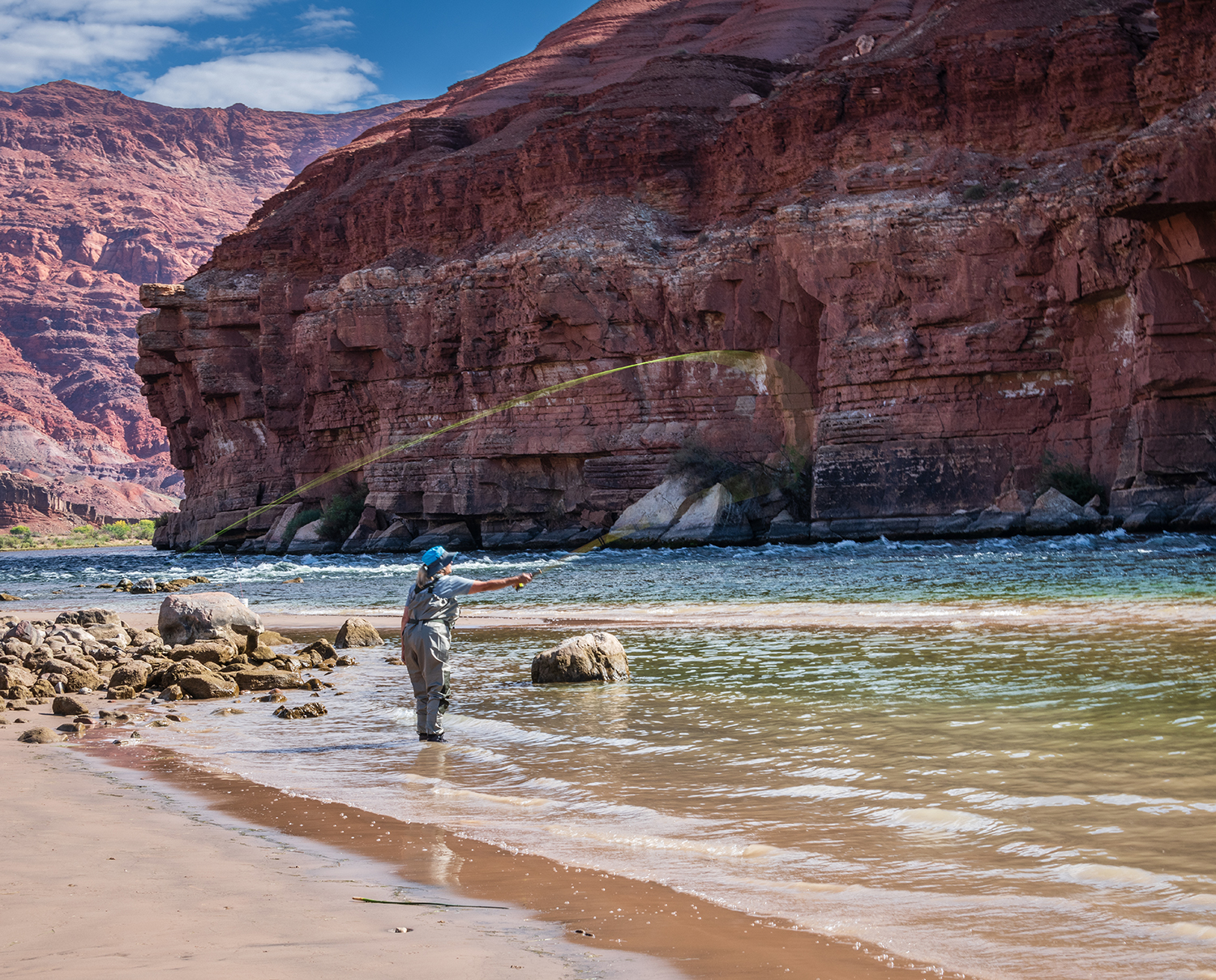 An angler casts into the Colorado River near Lees Ferry on a sunlit morning. By James Reeves