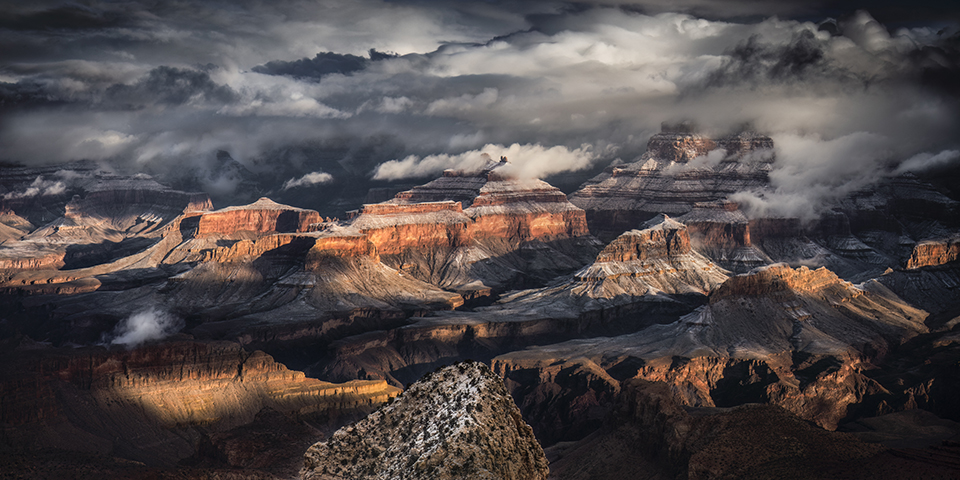 Clouds cast dramatic shadows on the formations of the Grand Canyon. By J Fritz Rumpf