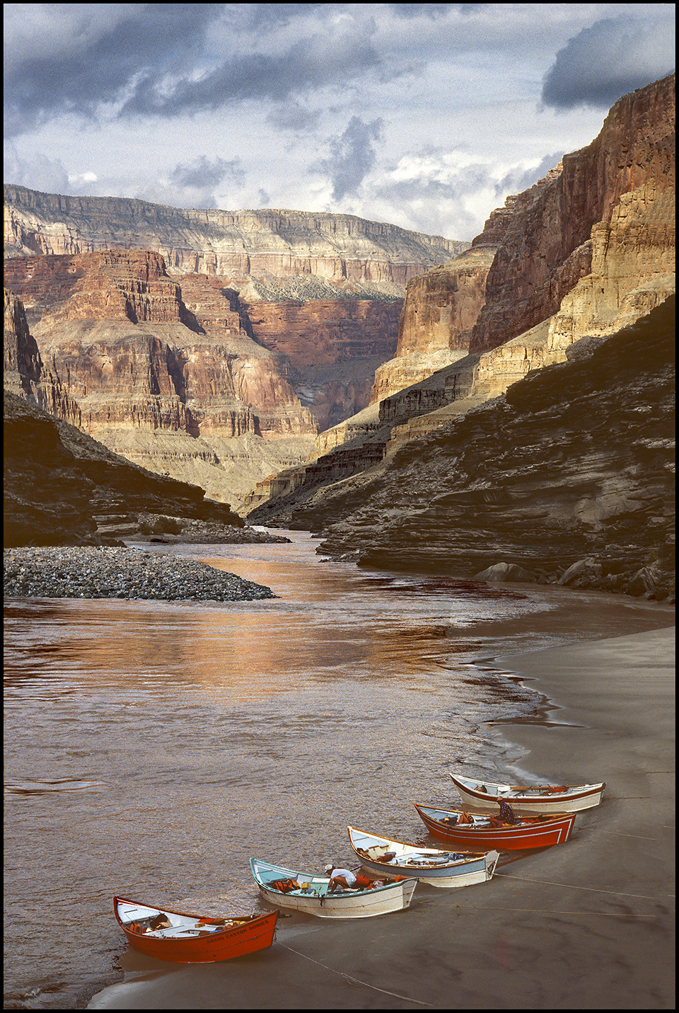 The dories shown here, looking downstream into the Canyon’s Conquistador Aisle, all are variations on the classic Oregon “drift boat.” One is made of composite material; the others are made of wood. Most of the boatmen and passengers are enjoying a hike up Blacktail Canyon.