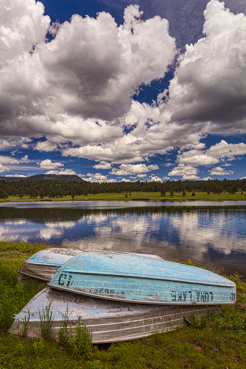 Old rowboats mark the shoreline of Luna Lake, near Alpine, as monsoon clouds gather above. When full, Luna Lake has a surface area of about 75 acres. By Claire Curran