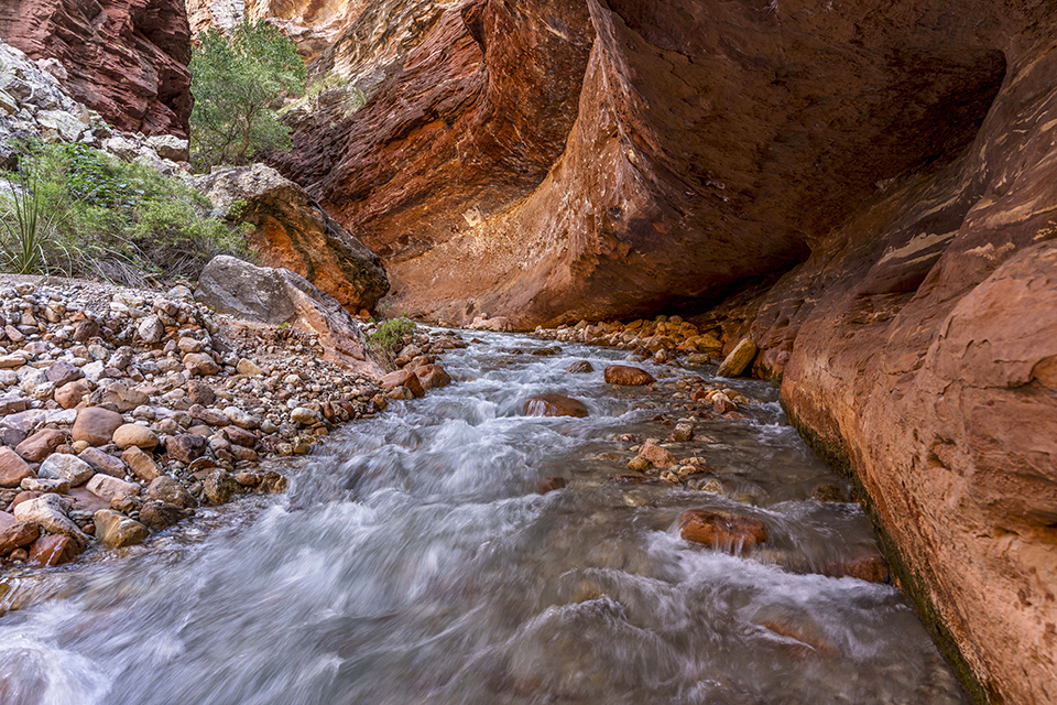 Water flows through a rock “tunnel” on Tapeats Creek, referred to in this story as the Thunder River. This spot is upstream from the confluence of the two waterways. By Rich Rudow
