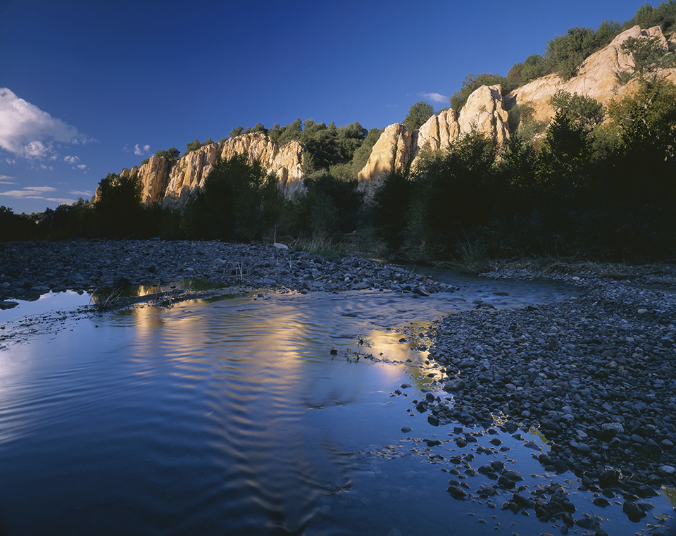The meandering Blue River reflects surrounding rock formations covered with piñon pines. The river runs for nearly 51 miles before it joins the San Francisco River northeast of Clifton. | Randy Prrentice
