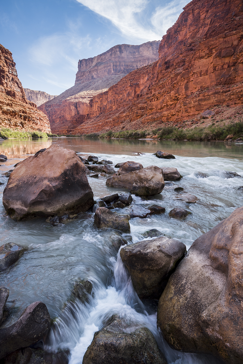 he Colorado River, the waterway that drains the plateau, tumbles through a maze of boulders in the Grand Canyon. By Gary Ladd