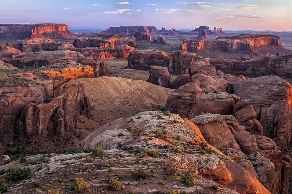 The buttes of Monument Valley, among the plateau’s best-known attractions, stretch toward the horizon in a sunrise view from Hunts Mesa. By Guy Schmickle