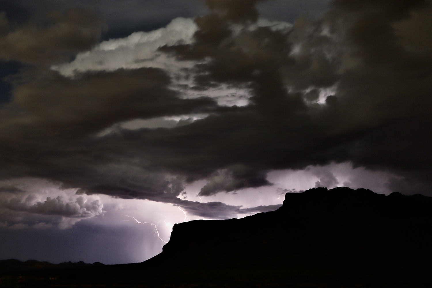 A storm releases lightning into the Superstition Mountains near Lost Dutchman State Park. By Frank Burrows