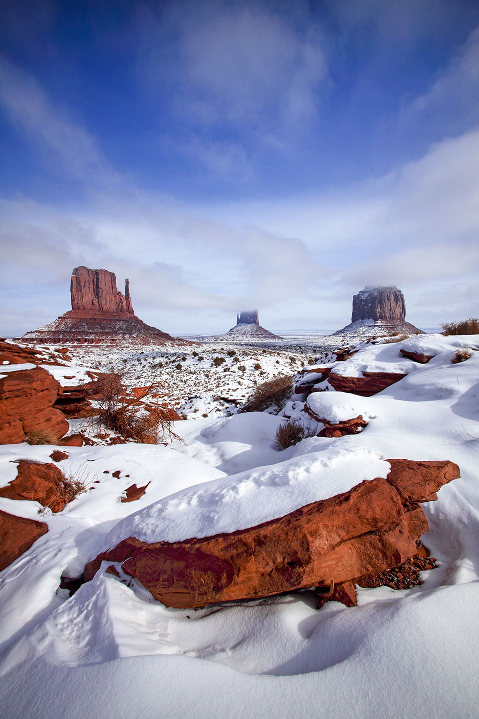 Low clouds and snow cloak the Mittens and Merrick Butte, three of the most photographed buttes in Monument Valley. This part of the Navajo Nation rarely sees this much snow — on average, less than 6 inches falls on Monument Valley each year. | Bruce D. Taubert