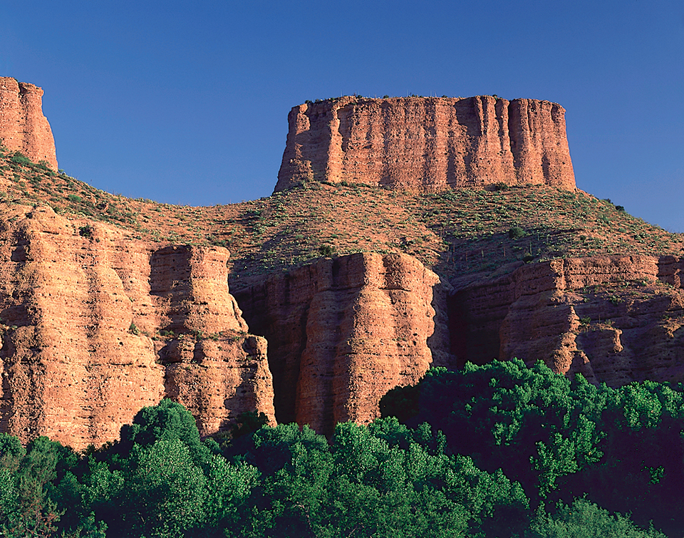 At the east end of Aravaipa Canyon Wilderness, a rock formation called The Chimney rises above the canyon and towers over verdant stands of cottonwood trees. By Randy Prentice