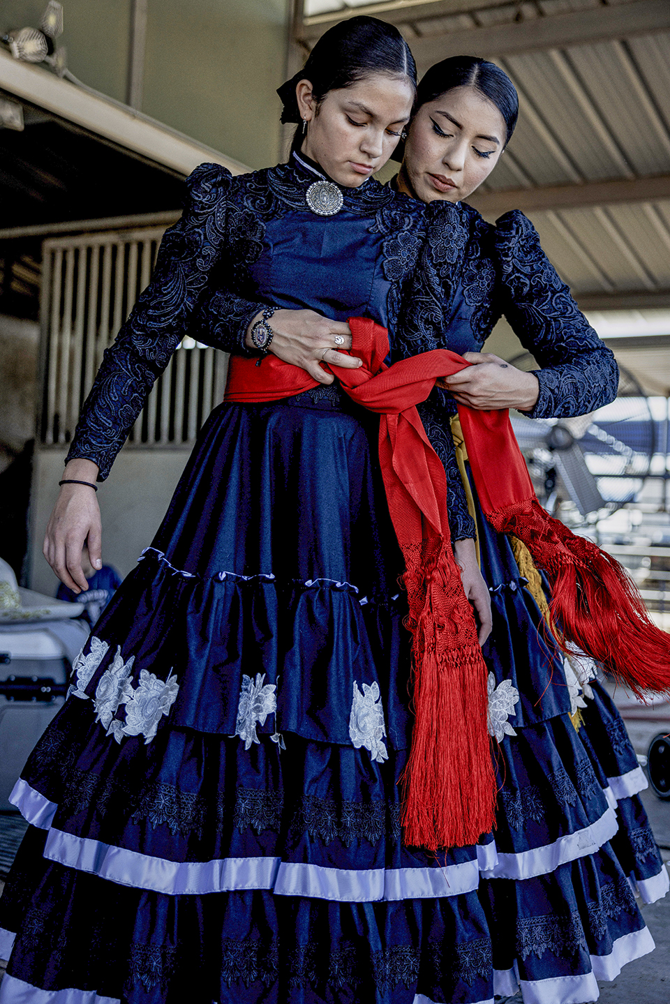 Amazonas de Corazón teammates  Ana Ochoa (left) and Sol Reyes adjust their uniforms for an event at Rancho Corona. Ana is the granddaughter of longtime escaramuza rider Yolanda Campos. | Adriana Zehbrauskas