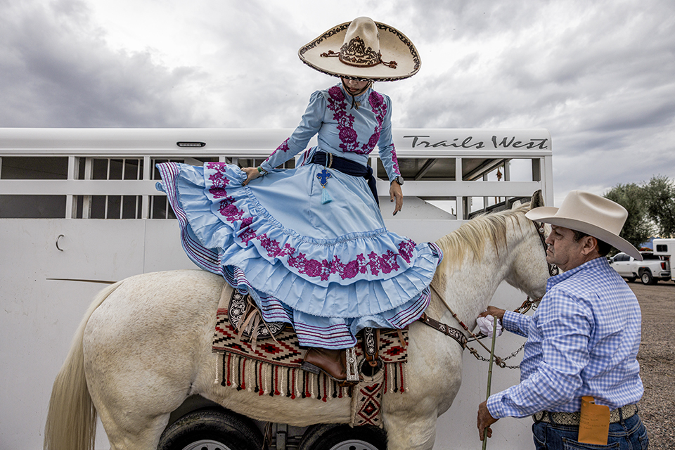 Beneath a cloudy sky, a member of the Rayenari team saddles up ahead of a November event, the Torneo del Desierto, at Rancho Corona. Like Amazonas de Corazón, Rayenari has several members from the same family. | Adriana Zehbrauskas