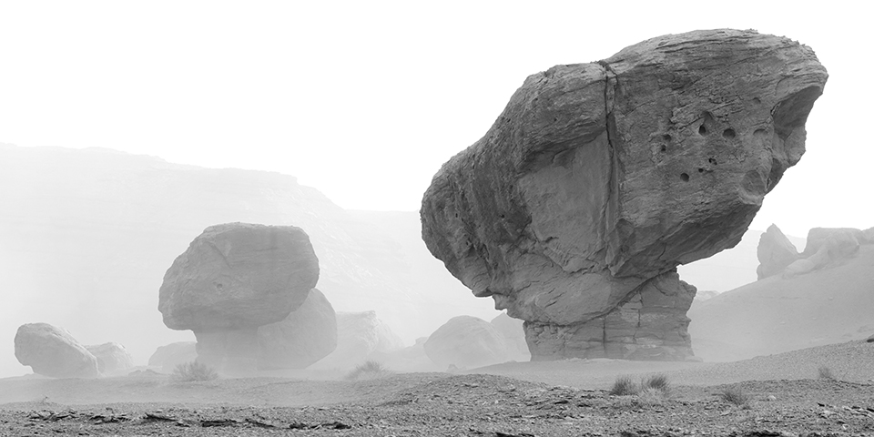 Fog at Marble Canyon partially obscures giant boulders, creating an otherworldly landscape in black and white. By Paul Martin