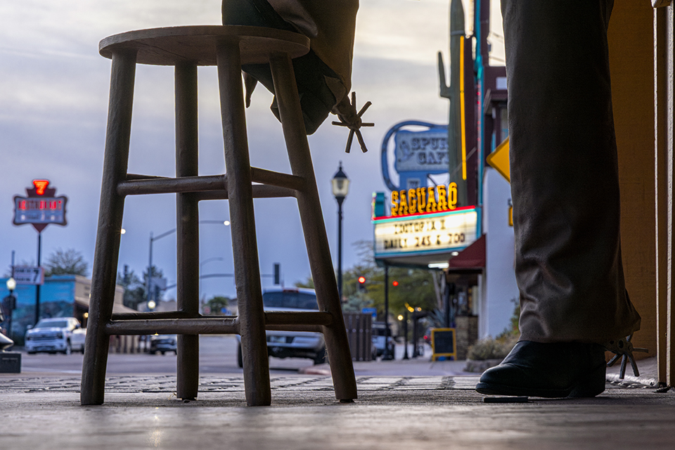 The Saguaro Theater’s sign shines brightly through a statue on Wickenburg Way. | Mark Lipczynski