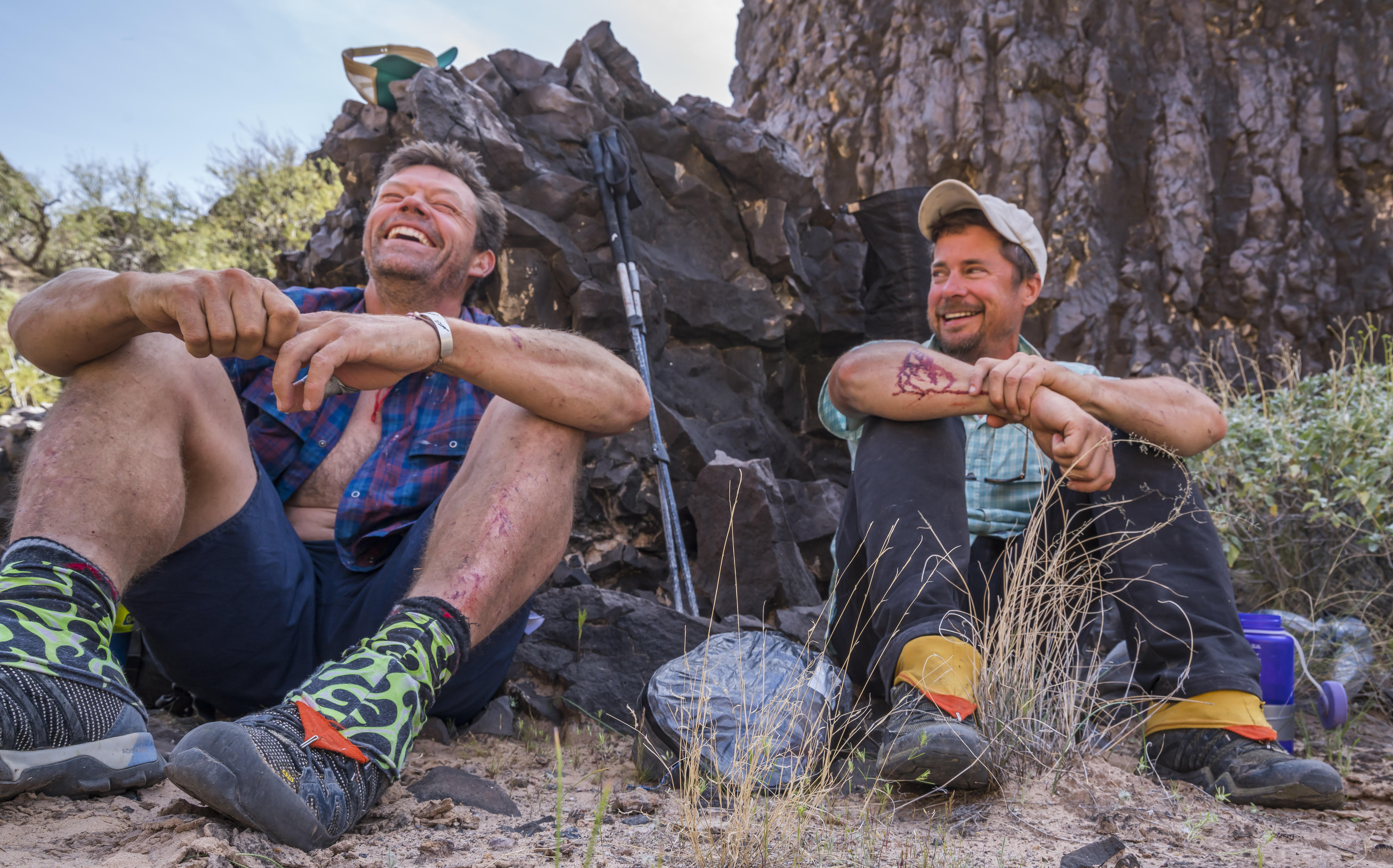 Kevin Fedarko, the best-selling author of A Walk in the Park: The True Story of a Spectacular Misadventure in the Grand Canyon, laughs with his companion as they sit  by a large rock.