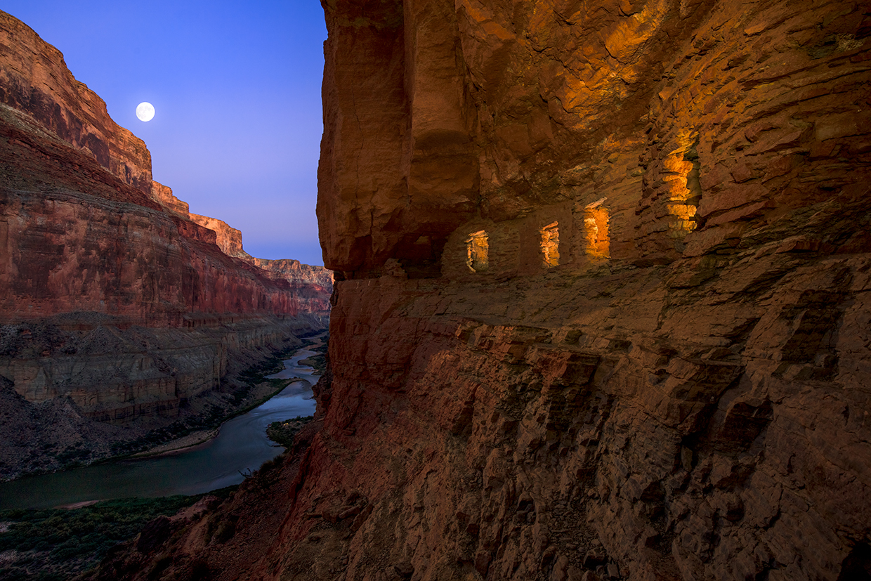 Light spills out of the Nankoweap granaries as the moon rises over the Colorado River at the Grand Canyon. | Adam Schallau