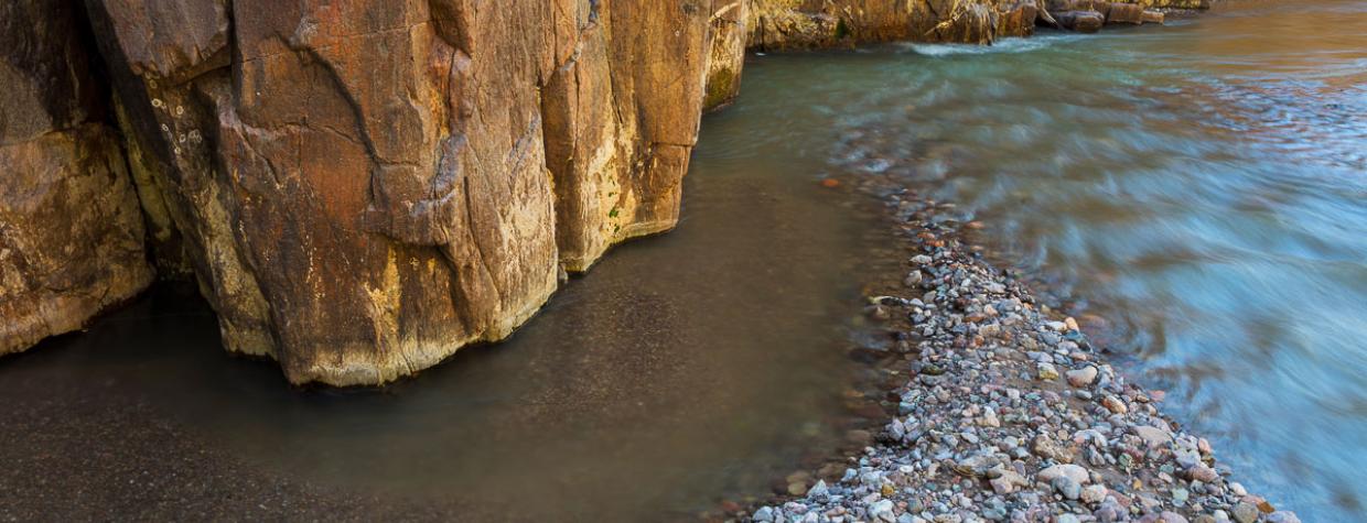 Cool water glides past warmly lit walls in Aravaipa Canyon. | Marc Strickland