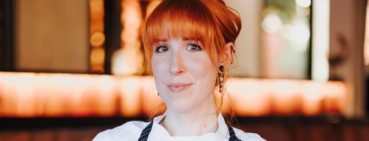 A red-headed chef displays a plate of grilled octopus in a dining room in Sedona. 