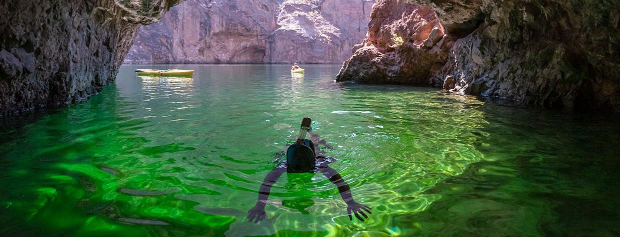 Diver in emerald-colored water inside a sea cave on the Colorado River. Photograph by Kerrick James.
