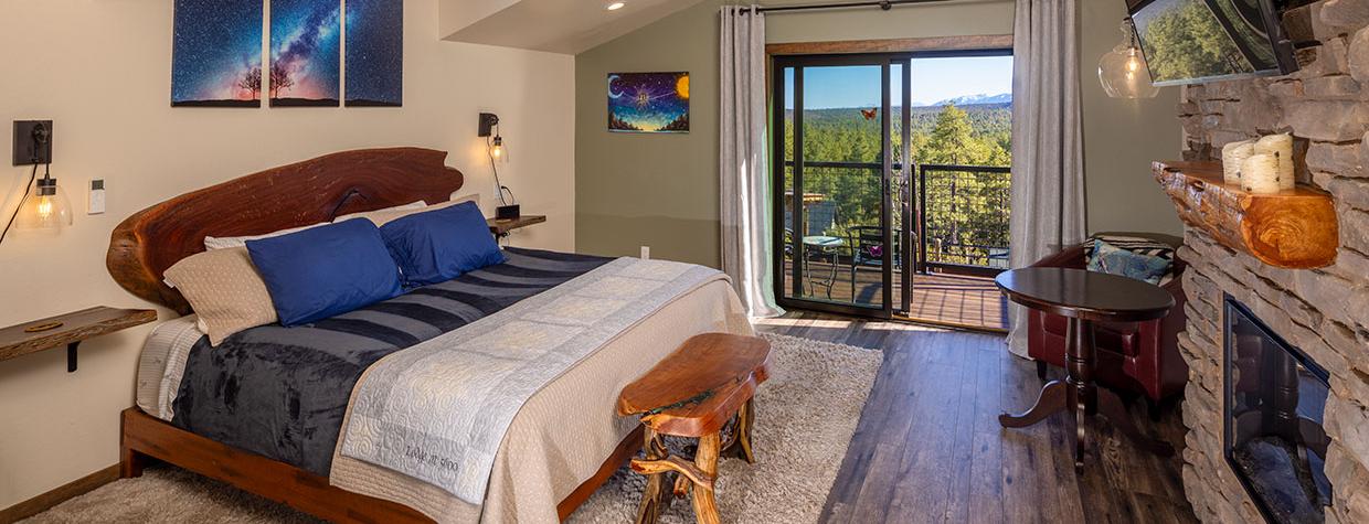 Interior of room at Lodge at 5600 with fireplace and view of pine forest. Photograph by John Burcham.