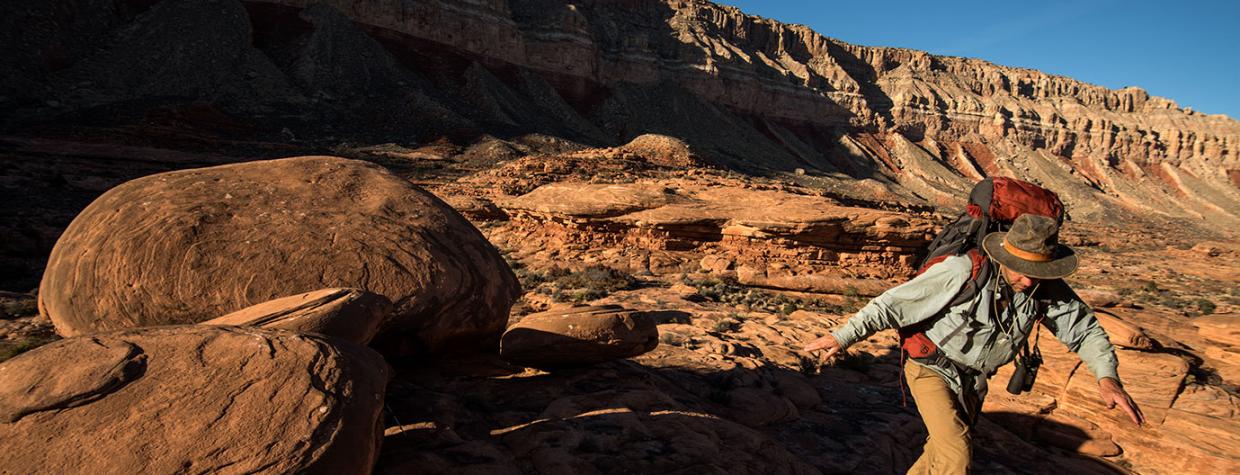 Writer Tyler Williams navigates around sandstone formations on the Esplanade below Fishtail Mesa. By Bill Hatcher