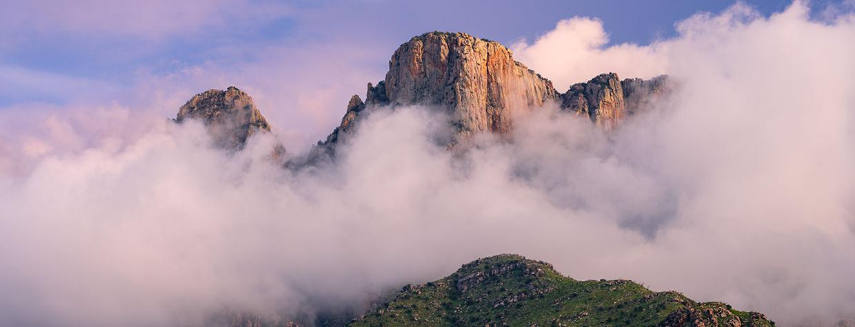  Low-hanging storm clouds cloak the cliffs of the Pusch Ridge Wilderness in the Santa Catalina Mountains, near Tucson.  By Jack Dykinga