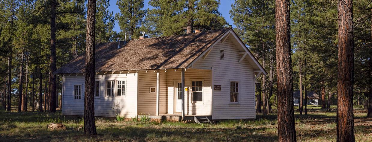 The research station is a small white building nestled between ponderosa pines. By John Burcham