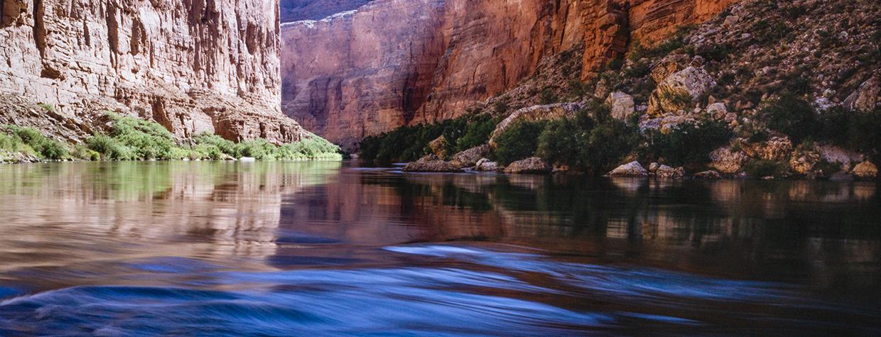 Summer sunlight pours into Marble Canyon, the upstream portion of Grand Canyon National Park, as the Colorado River flows over rocks. This spot is 41 miles downstream from Lees Ferry, considered the start of the Canyon’s 277-mile course. By Gary Ladd
