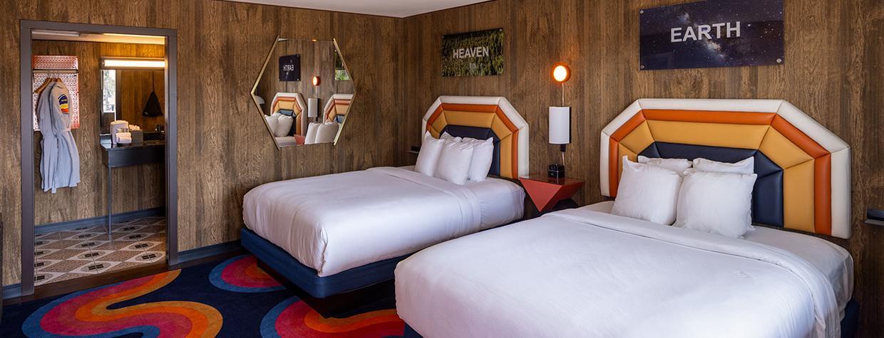 A room at the Americana Motor Hotel features a cheery mashup of bright yellows, oranges and blues with faux wood paneling that captures the flavor of a bygone era. By John Burcham
