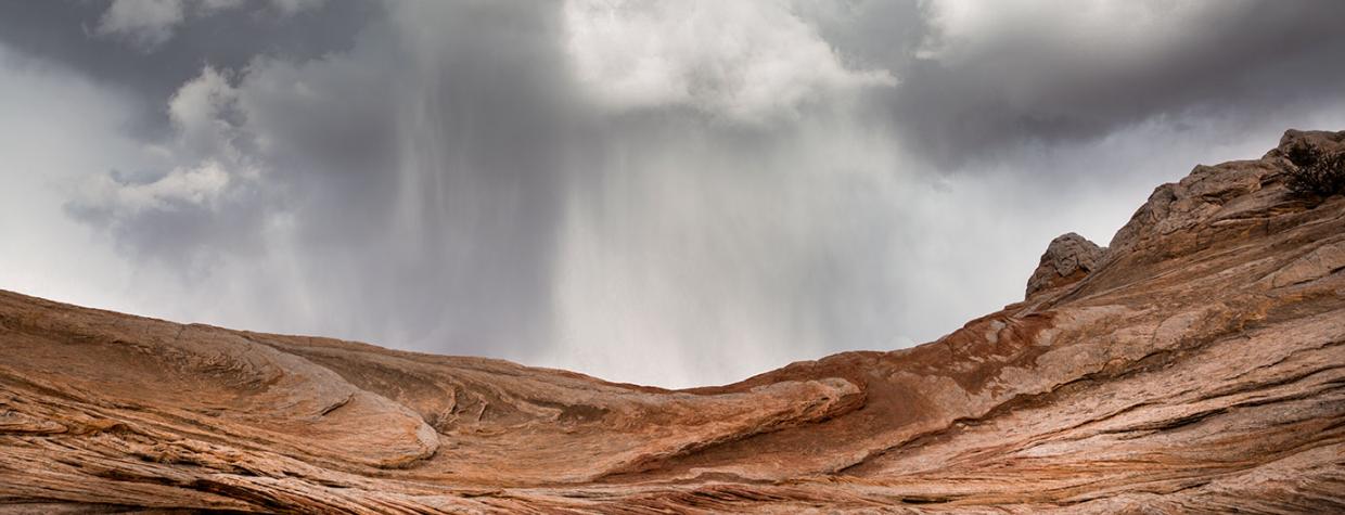 A sudden spring storm looms over the sandstone formations of White Pocket, part of Vermilion Cliffs National Monument north of the Grand Canyon. By Suzanne Mathia