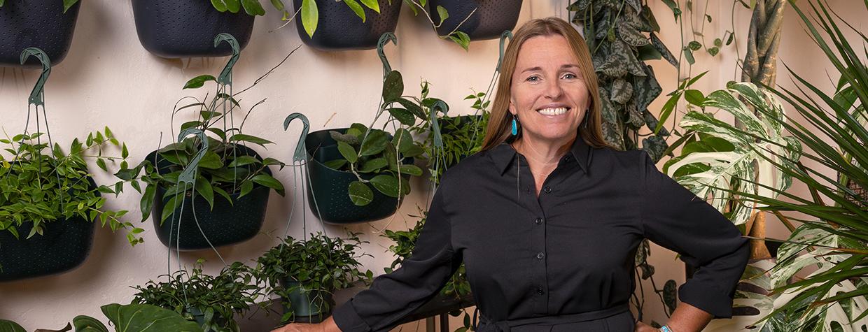 Chelsea Thomas poses amid dozens of green plants at Plantae in Flagstaff. By John Burcham