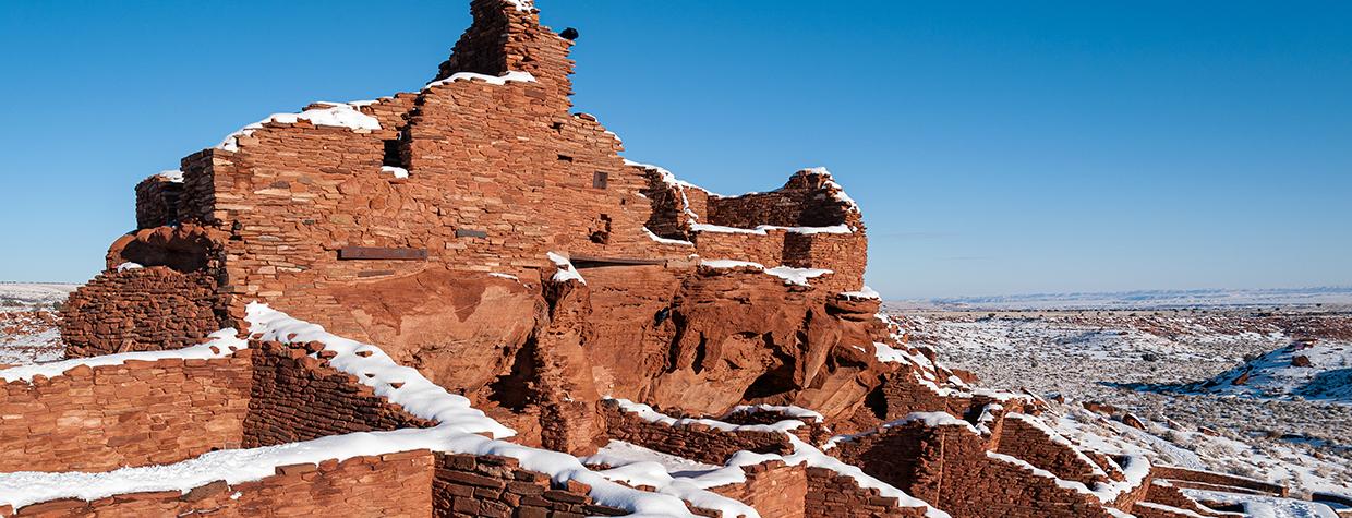A raven and a fresh coat of snow adorn Wupatki Pueblo, the centerpiece of Wupatki National Monument. The pueblo is accessible via a short walk from the monument’s visitors center. By Elias Butler