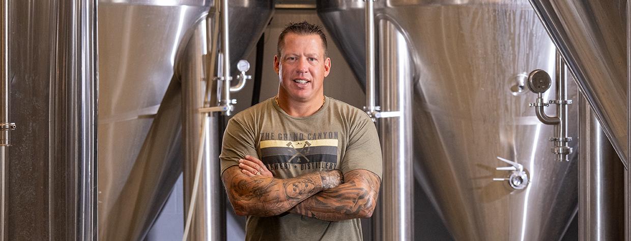 John Peasley stands near large vats at the Grand Canyon Brewing Co.