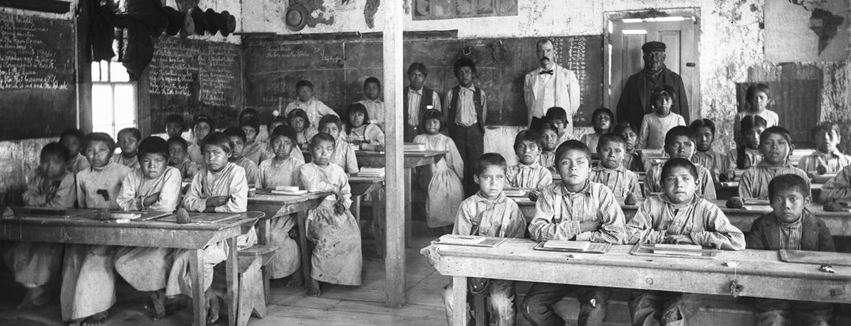 Students, teachers and other staff at a federal Indian boarding school in the Kingman area pose for a photo around 1900. | University of Southern California DIGITAL LIBRARY, California Historical Society Collection