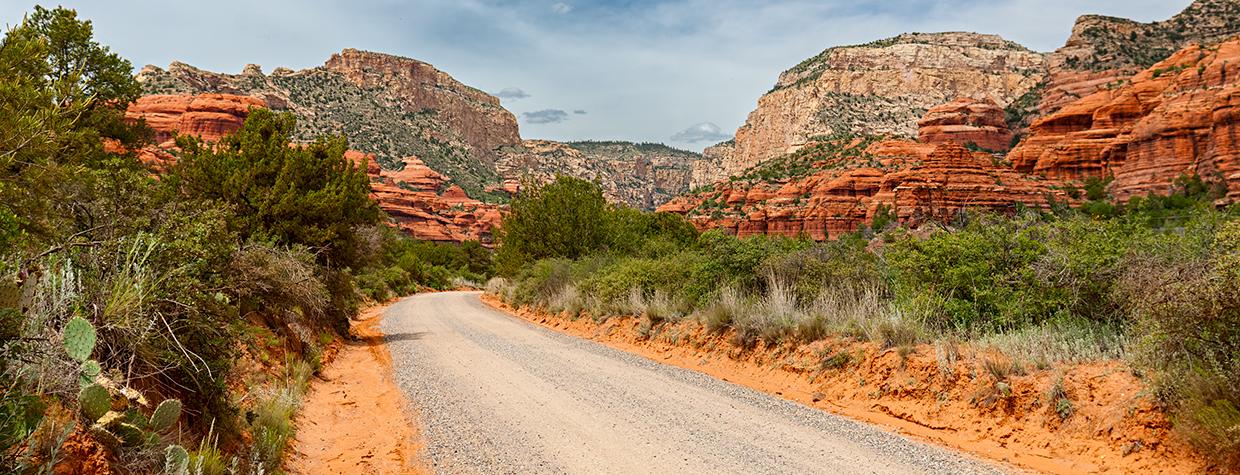 Well-maintained Forest Road 525 curves toward the sandstone buttes of Red Rock Country. By Derek von Briesen