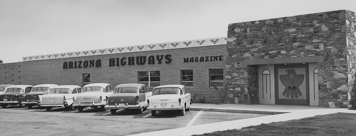 Black and white photo of Phoenix building that is home to Arizona Highways magazine, with mid-century automobiles parked in the front lot. | Arizona Highways Archives