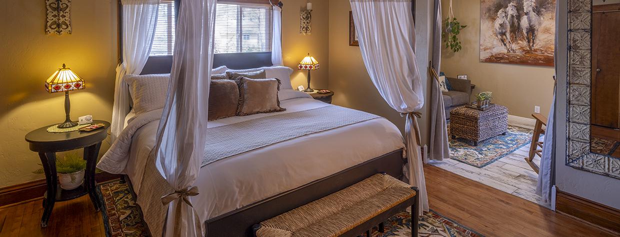 The intimate interior of a room at Kull features a poster bed, wooden floors and a separate sitting room. By John Burcham