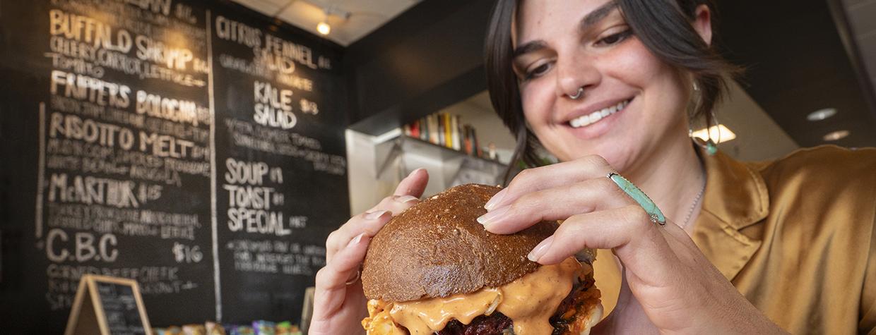 A woman prepares to take a bite of a big cheeseburger at JoeJoeBob's in Flagstaff. By Dawn Kish