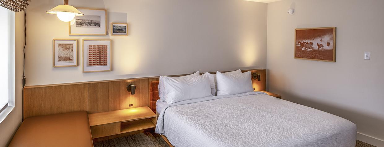 The interior of a room at Trailborn Grand Canyon features a large bed, sitting area and a desk. By John Burcham