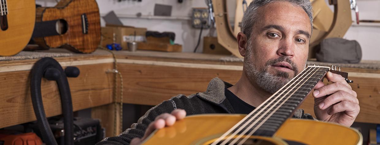 Ryan Elewaut is pictured looking down the neck of one of his guitars. By John Burcham.