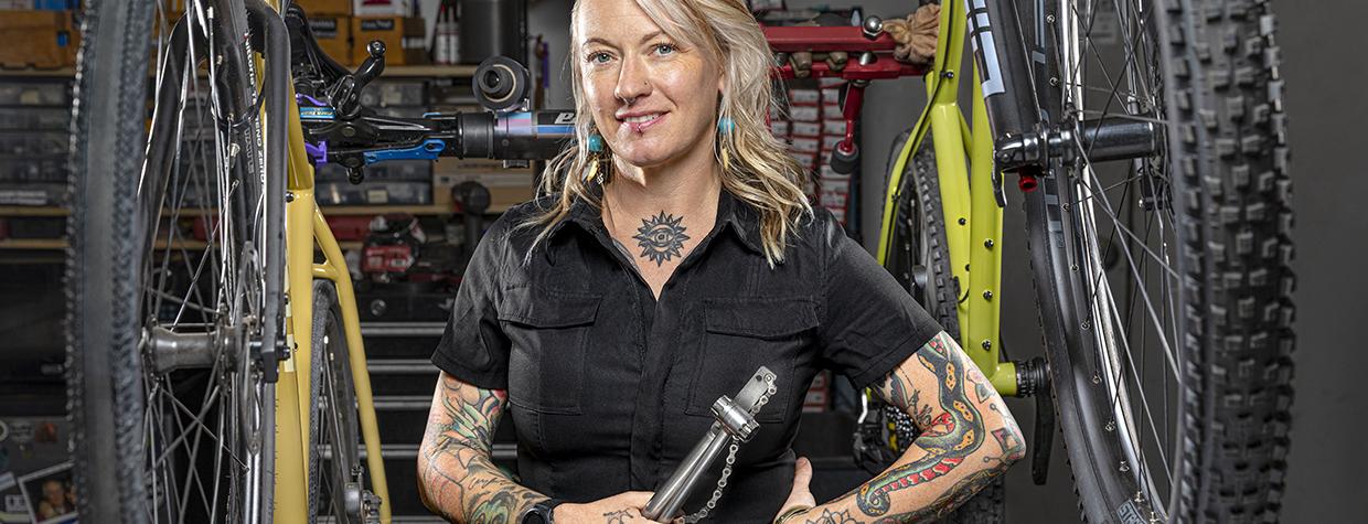 Jenna Majchrzak between bicycles and among tools at Transit Cycles, her bike shop. By Steven Meckler