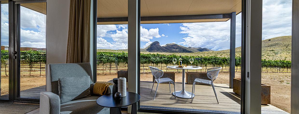 The view from inside a room at Los Milics Vineyards includes a covered patio overlooking the vineyard with a view of Mount Bruce and the Mustang Mountains in the distance. By Steven Meckler