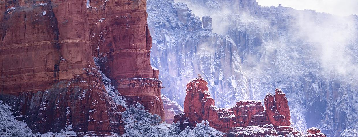 Fog and snow-covered foliage combine to form a wintry scene amid the sandstone buttes of Red Rock Country. The formations seen in the foreground are part of Snoopy Rock, named for its resemblance to the Peanuts character. | Larry Lindahl