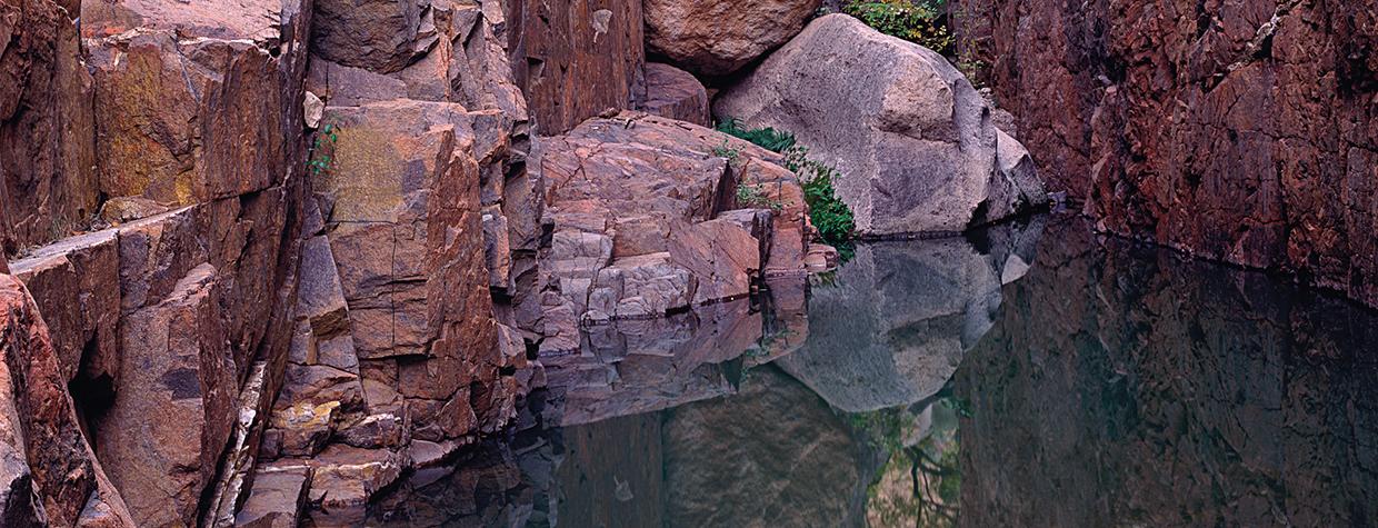 Placid water in Hell’s Half Acre Canyon reflects the sheer walls and box elders. By Jack Dykinga