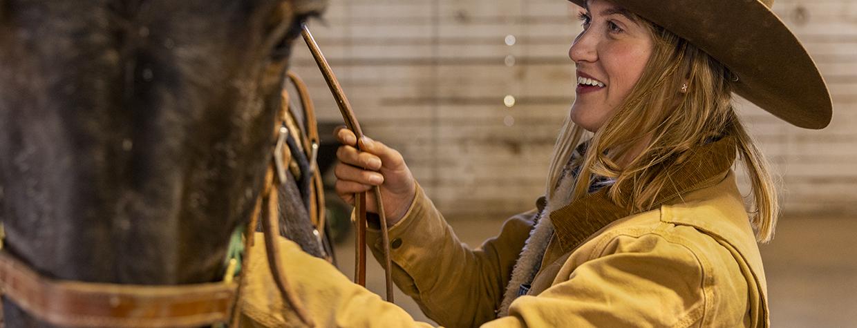Grand Canyon wrangler Remy Kelbel prepares one of the mules at the South Rim for a morning ride. Kelbel is one of up to nine wranglers employed at the Canyon by Xanterra Travel Collection. By John Burcham