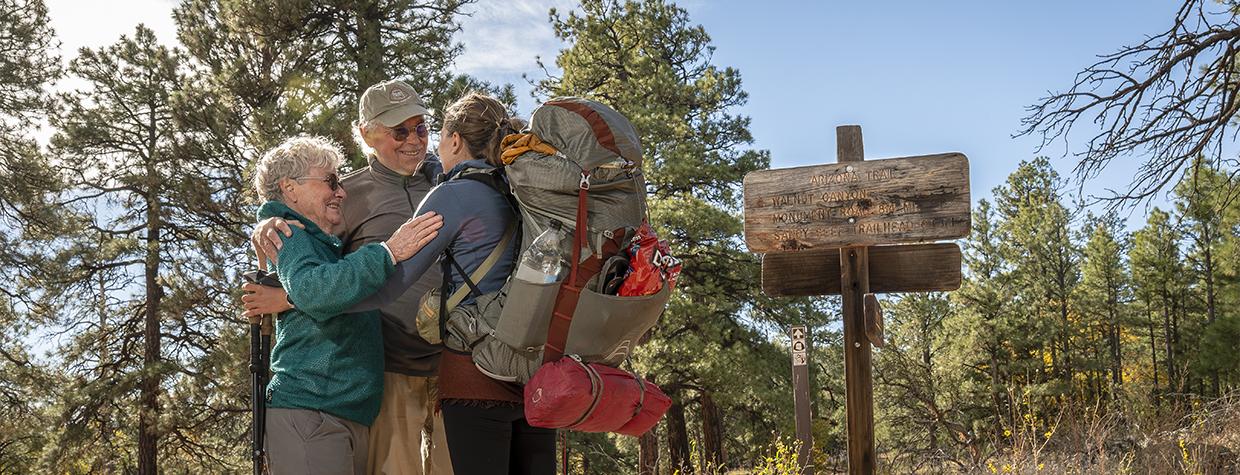 Arizona Trail thru-hiker Melina Keil, visiting from Germany, embraces “trail angels” Melody and Tim Varner on the trail near Flagstaff. Keil reached out to the Varners just a day before she was to arrive, and the couple sprang into action. | Dawn Kish