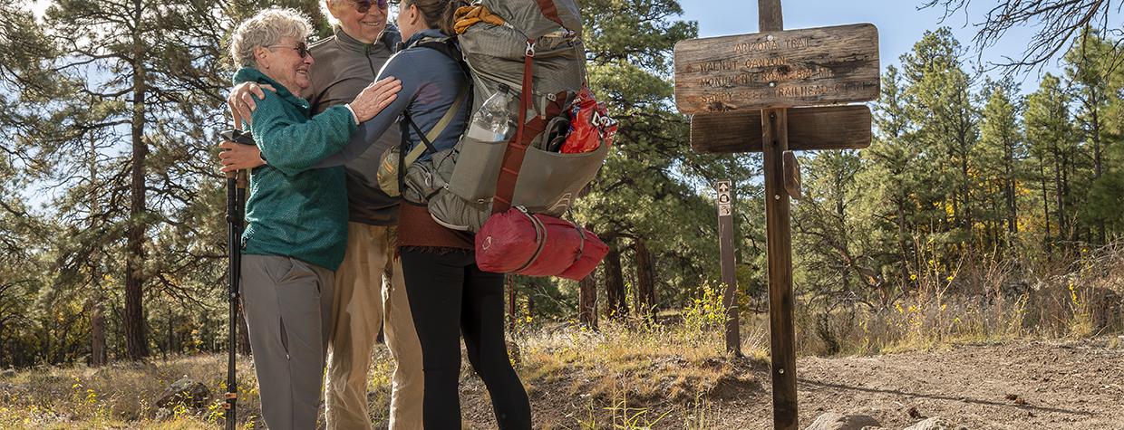Arizona Trail thru-hiker Melina Keil, visiting from Germany, embraces “trail angels” Melody and Tim Varner on the trail near Flagstaff. Keil reached out to the Varners just a day before she was to arrive, and the couple sprang into action. | Dawn Kish