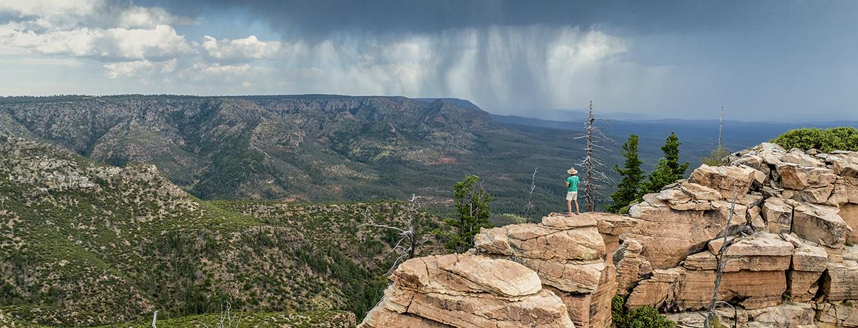 Writer Tyler Williams surveys a significant  rainstorm from the Mogollon Rim, east of Baker Butte. There, the Rim and the Arizona Divide make a sharp turn toward the east. | John Burcham