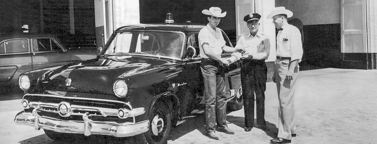 Tex Earnhardt (left) delivers a new 1952 Ford Mainline police car to the Chandler Police Department at the original Earnhardt Ford location in downtown Chandler. | Courtesy of Earnhardt Ford